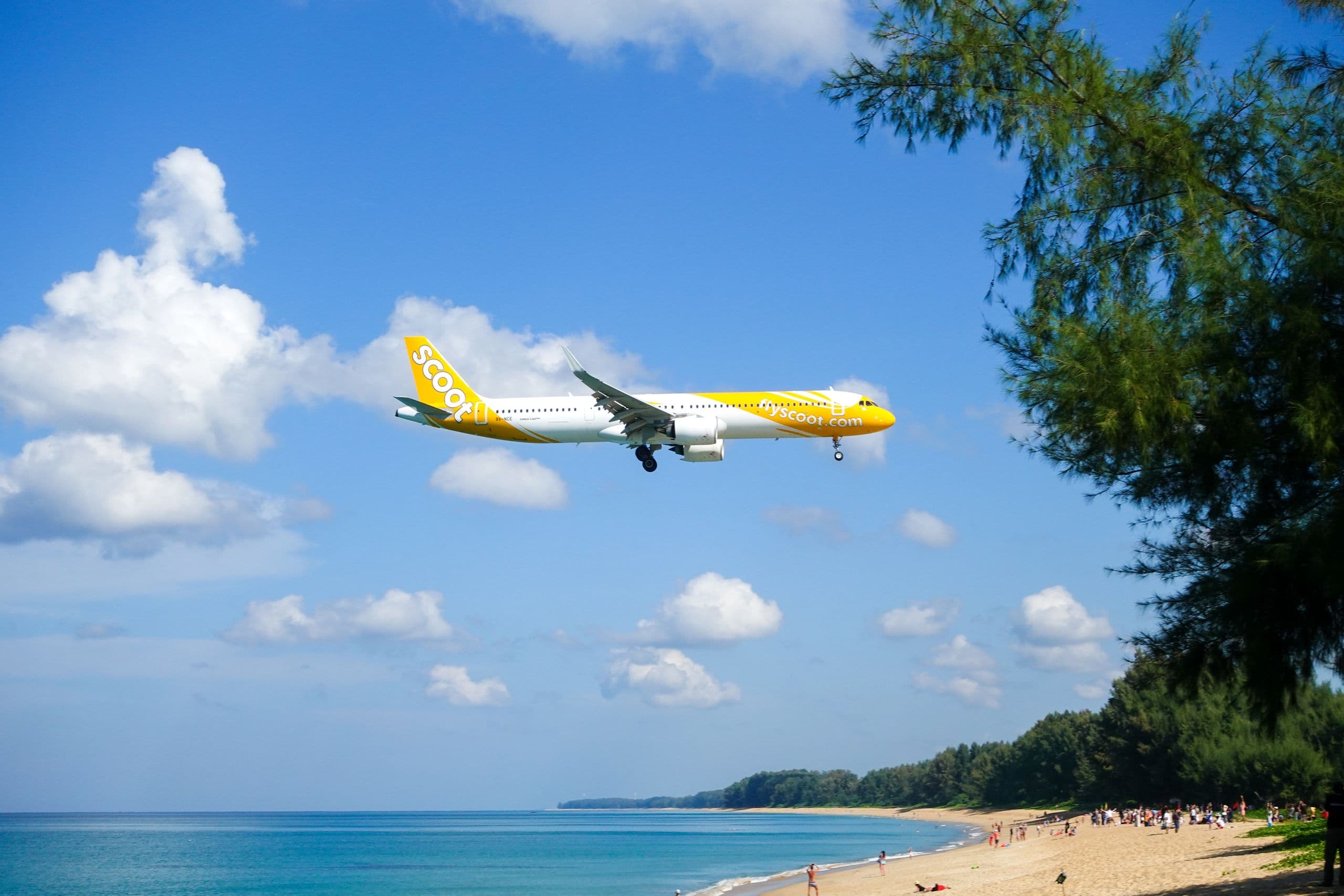 Ein Flugzeug im Endanflug über dem Strand von Mai Khao, dem Sand am Nordende der Landebahn des Flughafens Phuket