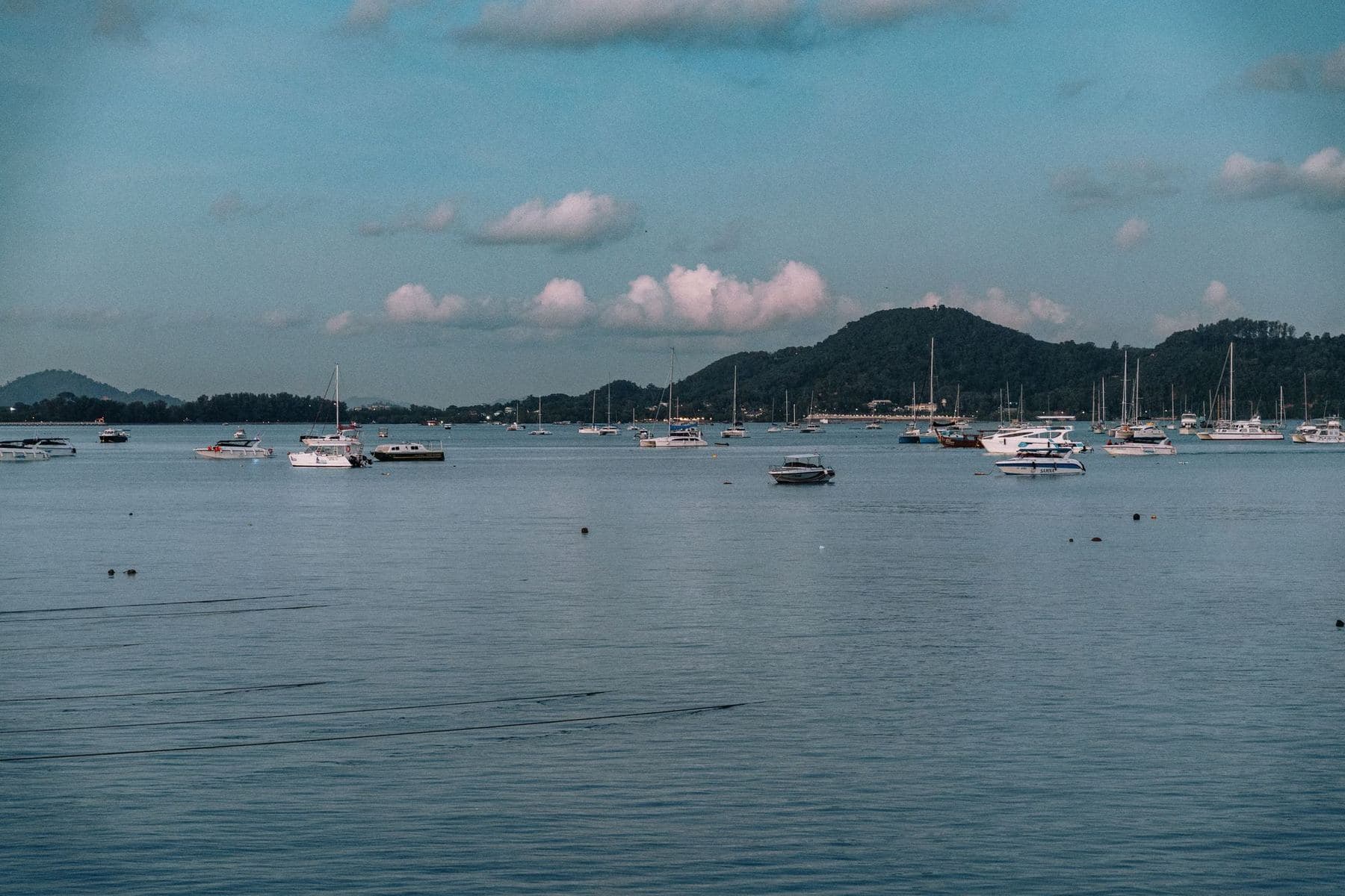 Yachten vor Anker in einer ruhigen Bucht unterhalb von Hügeln auf Phuket