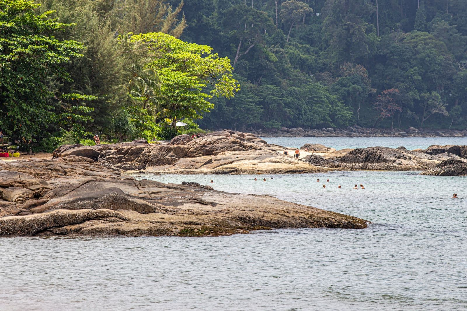 Felsen und klares, flaches Wasser am Nordende des Strandes von Khao Lak