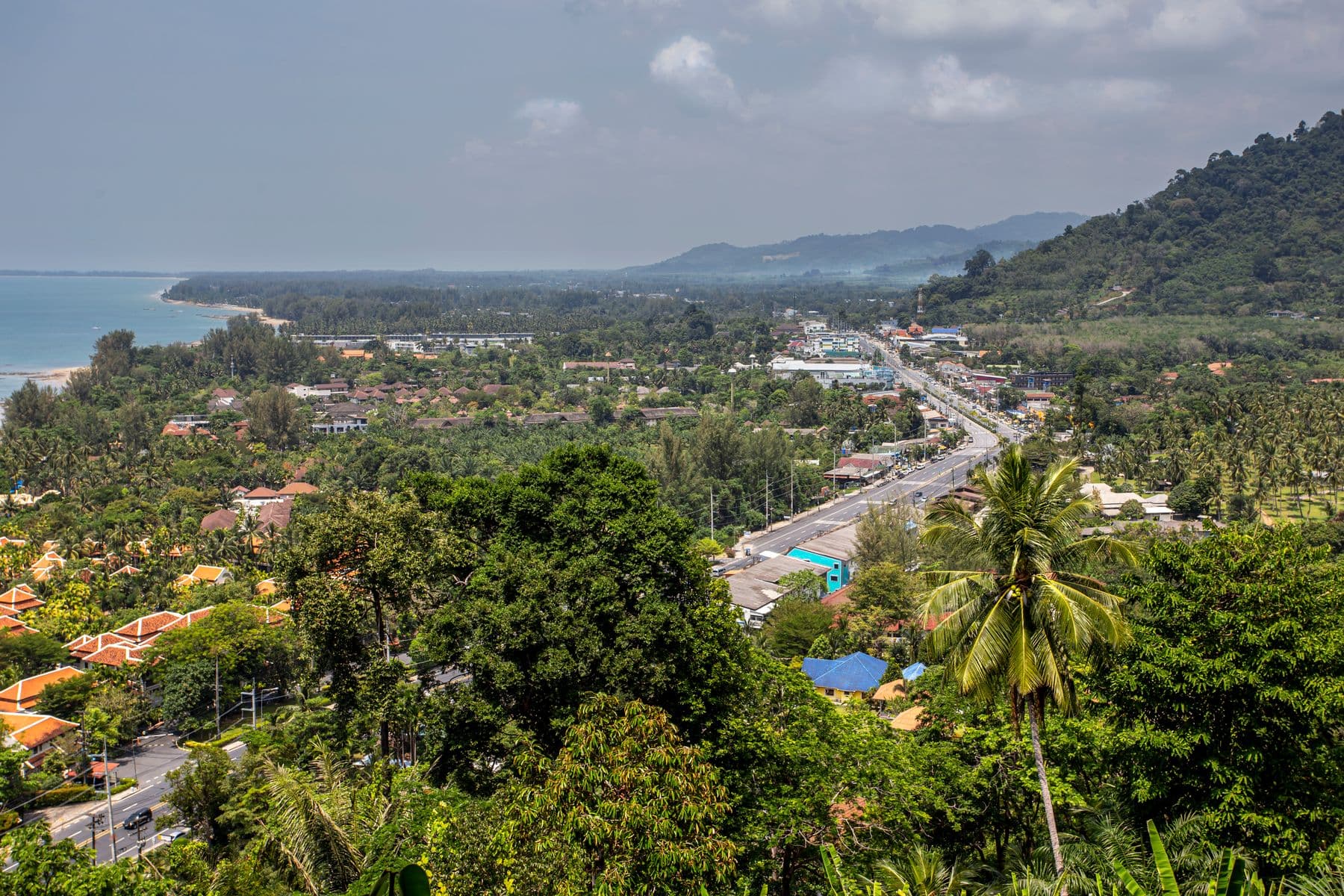 Die Küstenstraße, die nördlich durch Khao Lak führt, links die Andamanensee und dahinter bewaldete Hügel